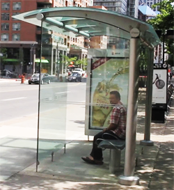 a bus shelter with someone sitting down inside of it
